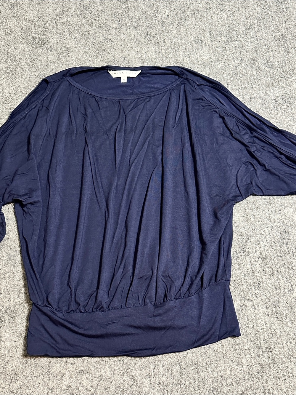 This is a dark navy blue boatneck pullover featuring a gathered blouson waist